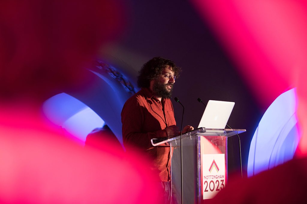 A man giving a speech from a podium marked Nottingham 2023