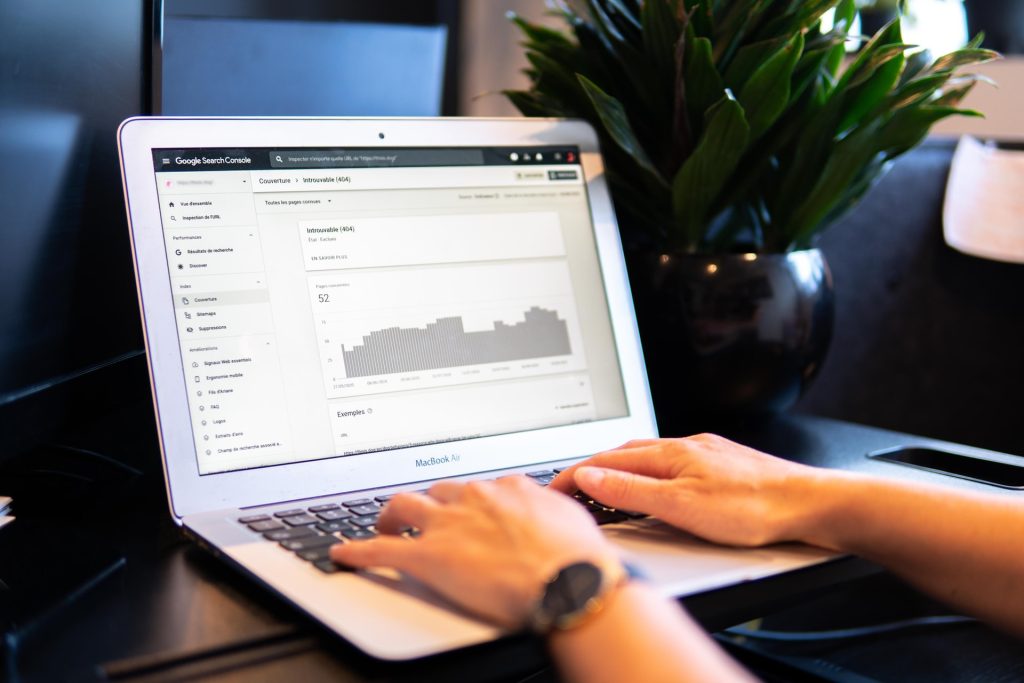 An image of a laptop showing the interface of Google search console. Two hands are resting on the keyboard